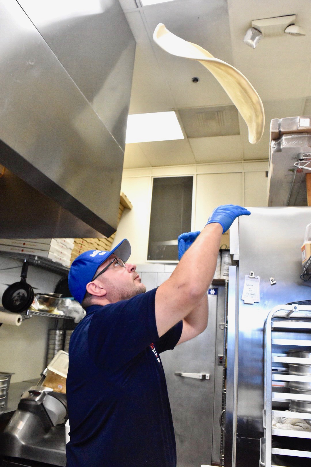 Photo of a man throwing a pizza dough into the air
